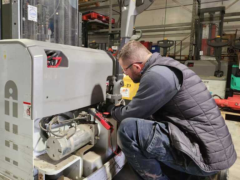 Photo d'un technicien de maintenance en cours de réalisation d'un entretien sur un gerbeur