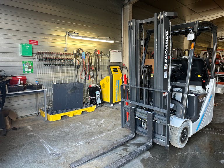 Photo d'atelier d'un espace dédié à la régénération de batterie avec un chariot élévateur unicarriers