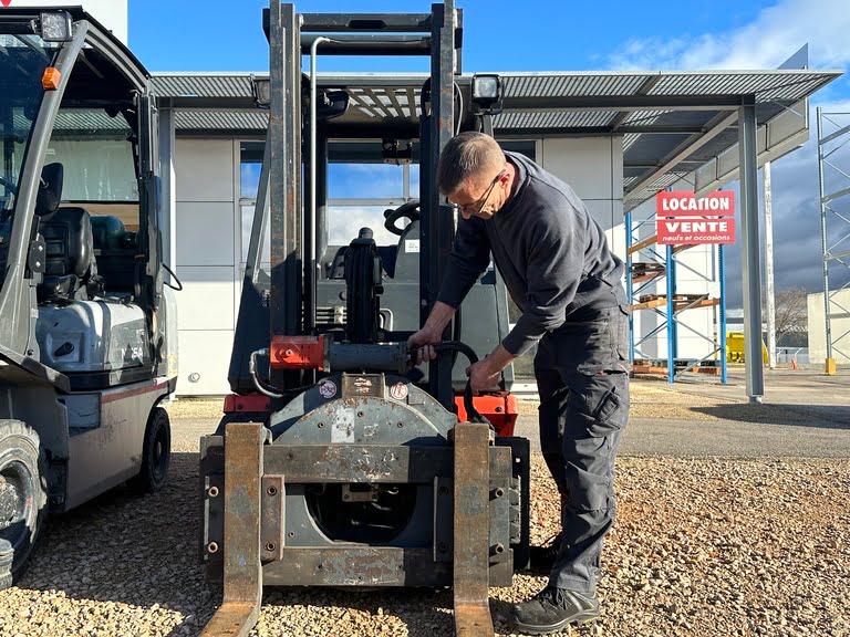 Photo d'un technicien intervenant sur le flexible hydraulique d'un chariot élévateur frontal