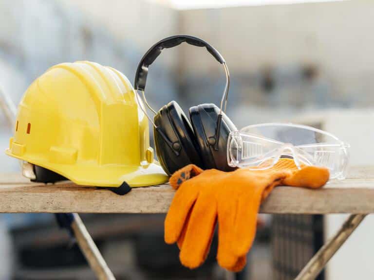 Image représentant des équipements de protection individuelle (EPI) : des gants, un casque, un casque antibruit et une paire de lunettes de protection