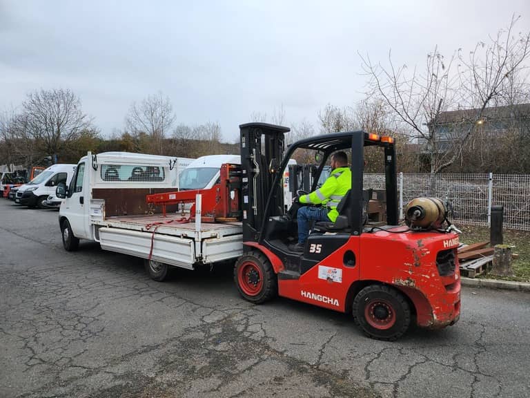 Un technicien dépose un accessoire de levage sur un camion