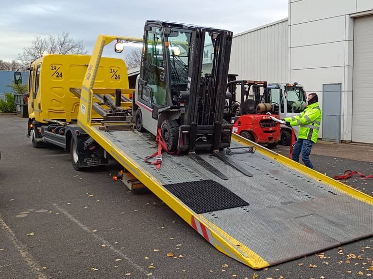 Un technicien de Siem Services effectue une intervention de dépannage sur un chariot élévateur à l'aide de son camion porteur remorqueur