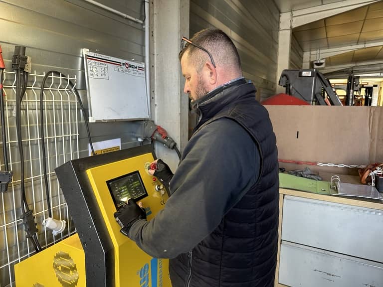 Photographie d'un technicien Siem Services en atelier procédant à une régénération de batterie sur une borne de recharge de la marque Energic Plus