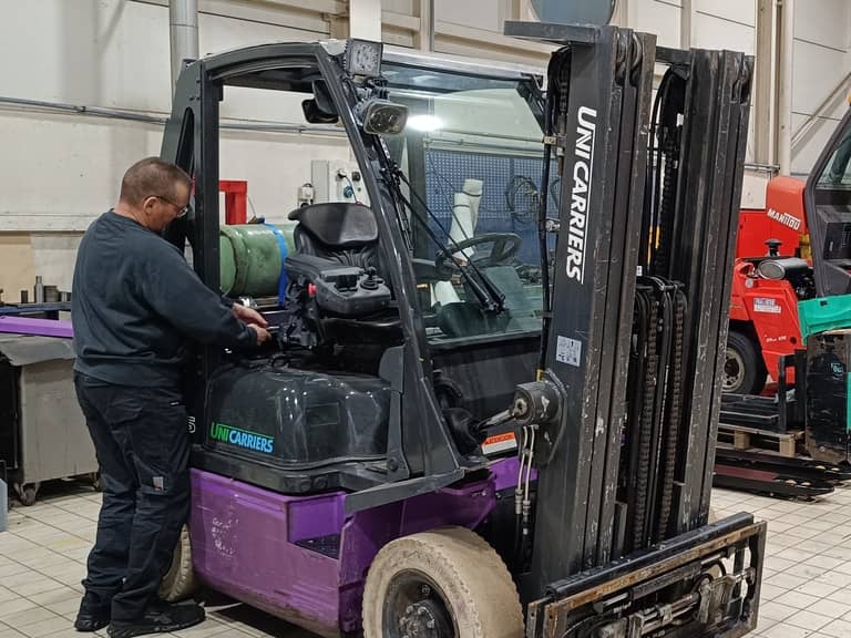 Un technicien Siem Services effectue une maintenance sur un chariot élévateur frontal Unicarriers