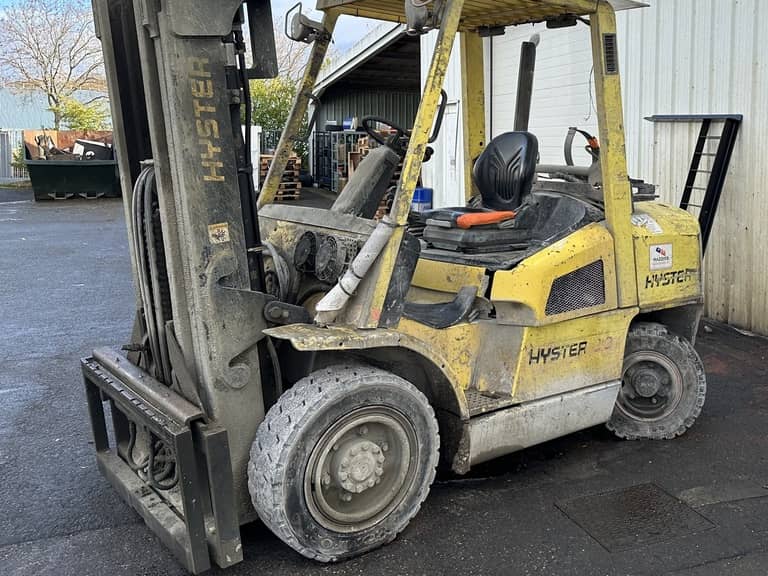 Un chariot élévateur frontal Hyster usé situé à l'arrière d'un établissement